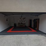 Flexspec DiamondFlex Pro solid garage floor tiles in black with a safety red border, installed in a home workshop with a workbench.